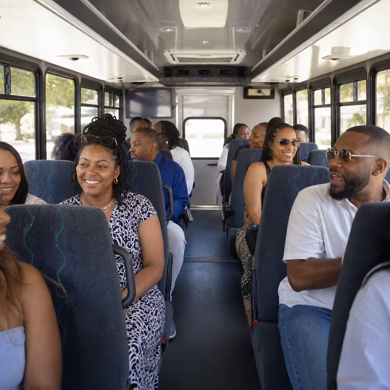 Group boarding a white charter bus for Private Event Transportation transportation in Elizabeth