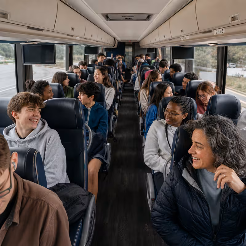 Group boarding a white charter bus for School Transportation transportation in Elizabeth